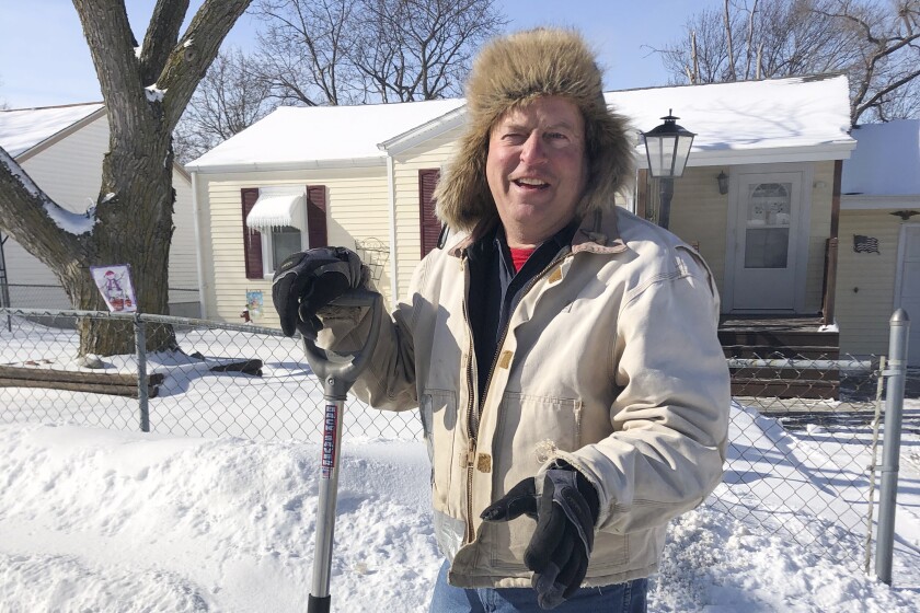 Tracy Fackler pauses from clearing the sidewalk in front of his home, Tuesday, Feb. 9, 2021, in Omaha, Neb. The 63-year-old auto mechanic praises Nebraska Republican Sen. Ben Sasse for condemning former President Donald Trump's actions before the Jan. 6 Capitol riot. "I'd rather have him say what he's seeing and what he's thinking," Fackler said. (AP Photo/Tom Beaumont)