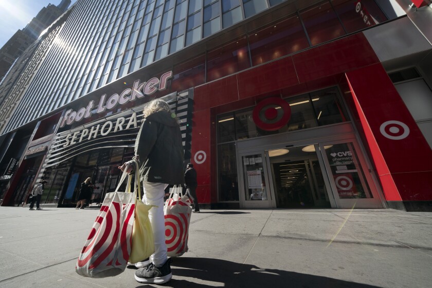 A woman carries Target shopping bags as she leaves the store, Monday, April 19, 2021 in New York. Retail sales in the U.S. were flat in April, after soaring in March, when many Americans received $1,400 stimulus checks that boosted spending. The report from the U.S. Commerce Department was worse than the 0.8% growth Wall Street analysts had expected. (AP Photo/Mark Lennihan)