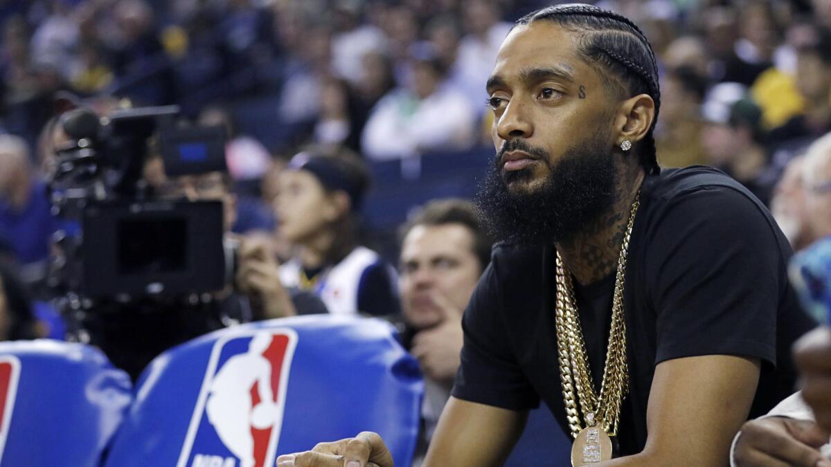 Rapper Nipsey Hussle watches the Golden State Warriors and Milwaukee Bucks play on March 29, 2018, in Oakland. The Grammy-nominated artist was shot and killed Sunday in Los Angeles.