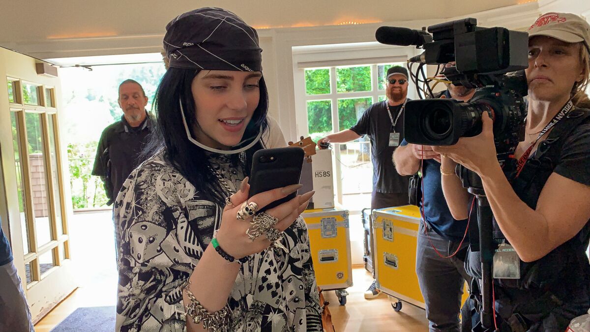 Billie Eilish being filmed as she checks her phone for the documentary from director R.J. Cutler. 