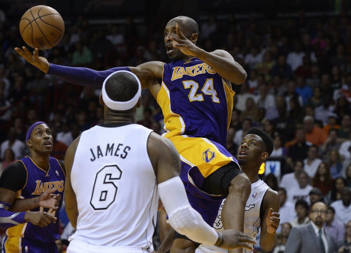 Kobe Bryant snags the ball against the LeBron James and the Miami Heat.
