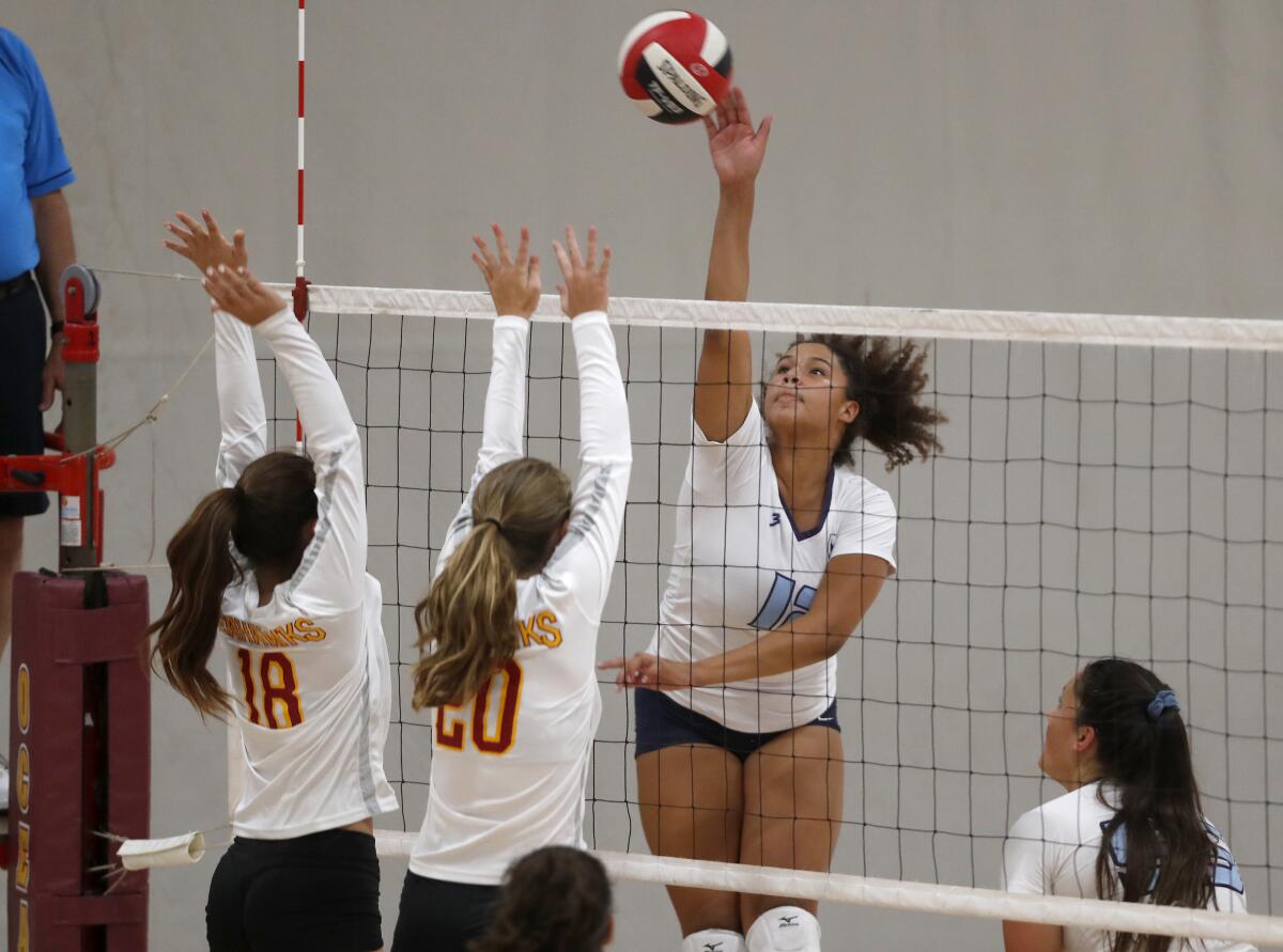 Taryn Akins of Marina spikes the ball over Ocean View's Ava Arce (18) and Emma Santy (20) in the first set of a nonleague match on the road Tuesday.