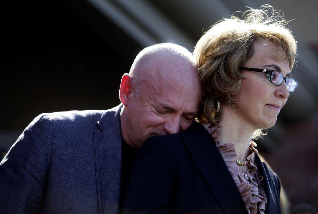 Mark Kelly leans on wife Gabby Giffords at a news conference in March 2013 in Tucson, site of the 2011 shooting in which six people died and Giffords was seriously wounded. The event was to push for stricter gun control.