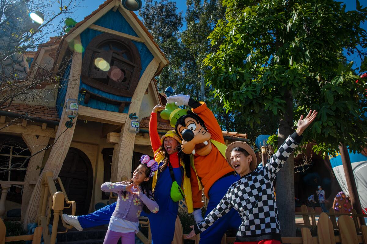 Goofy poses with visitors in Toontown at Disneyland in March 2023.