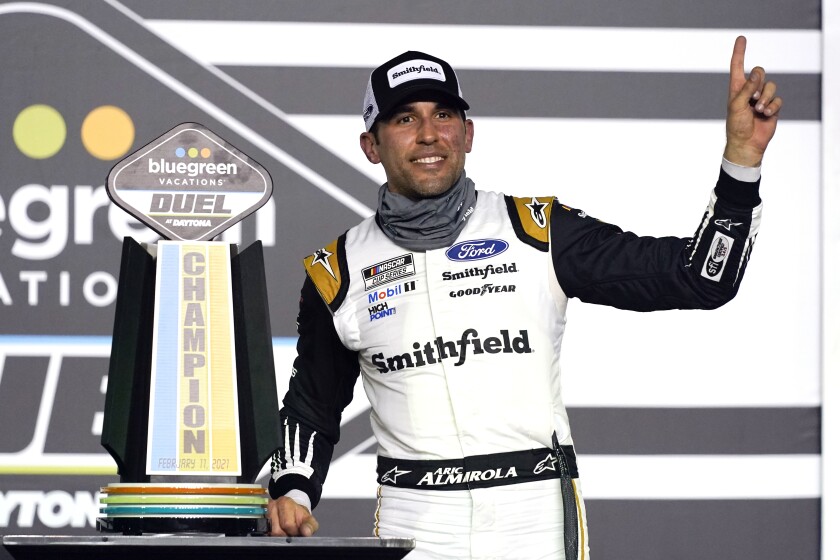 Aric Almirola celebrates in Victory Lane after winning the first of two qualifying NASCAR races.