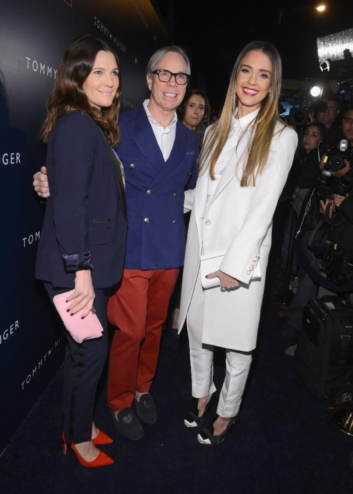 From left , Drew Barrymore, Tommy Hilfiger and Jessica Alba pose at the Tommy Hilfiger West Coast flagship opening in West Hollywood on Wednesday.