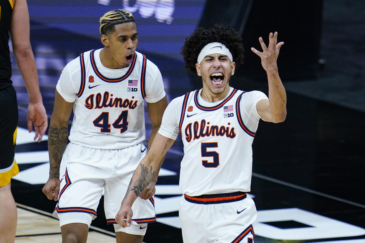 Illinois guard Andre Curbelo (5) celebrates with Adam Miller (44) after scoring following a steal against Iowa in the first half of an NCAA college basketball game at the Big Ten Conference tournament in Indianapolis, Saturday, March 13, 2021. (AP Photo/Michael Conroy)