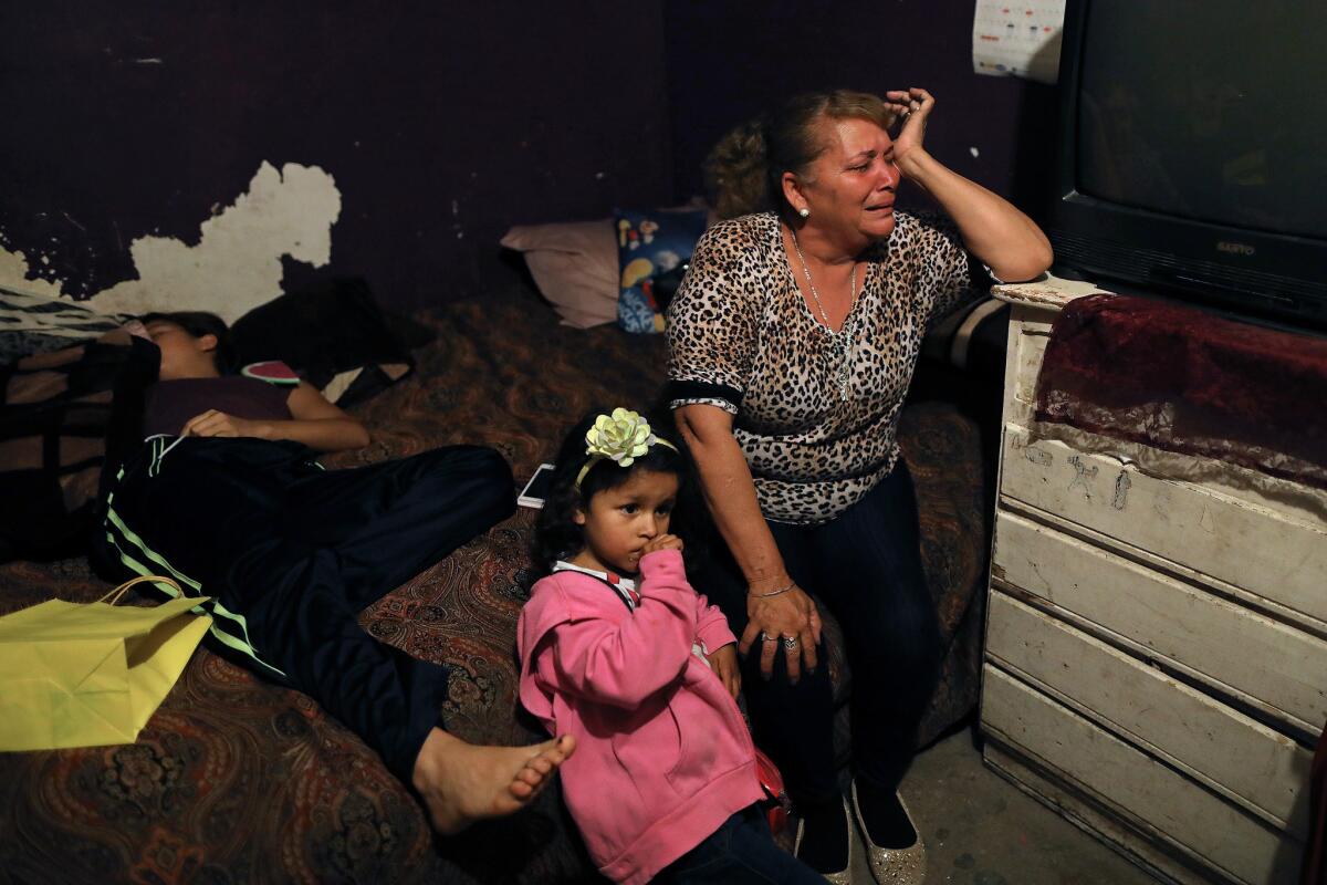 Bertha Peña, 59, with granddaughter Michel Noriega, weeps for her slain son Rafael Noriega Peña in Tijuana.