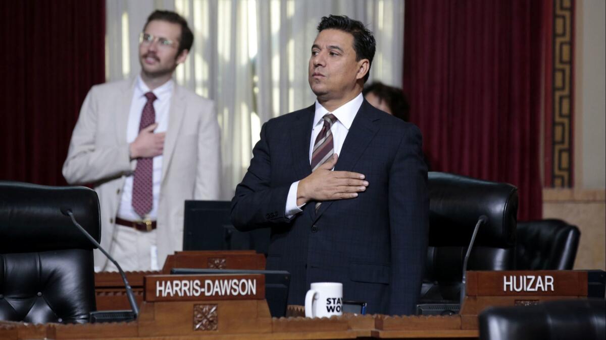 LA City Councilman Jose Huizar says the pledge of allegiance after appearing at his first City Council meeting since his home and offices were raided by the FBI.