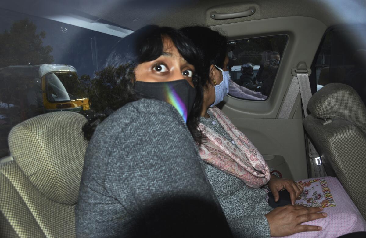 FILE - In this Feb. 22, 2021, file photo, climate activist Disha Ravi, 22, travels in a car as she is taken to a court in New Delhi, India. To her friends, Ravi, was most concerned about her future in a world where temperatures are rising. But her life changed last month as she became a household name in the country, dominating news coverage after police charged her with sedition, a colonial-era law which carries a sentence up to life. Her alleged crime: sharing an online document to help amplify months-long farmer protests in India on Twitter. She was released after 10 days in custody. (AP Photo/Dinesh Joshi, File)