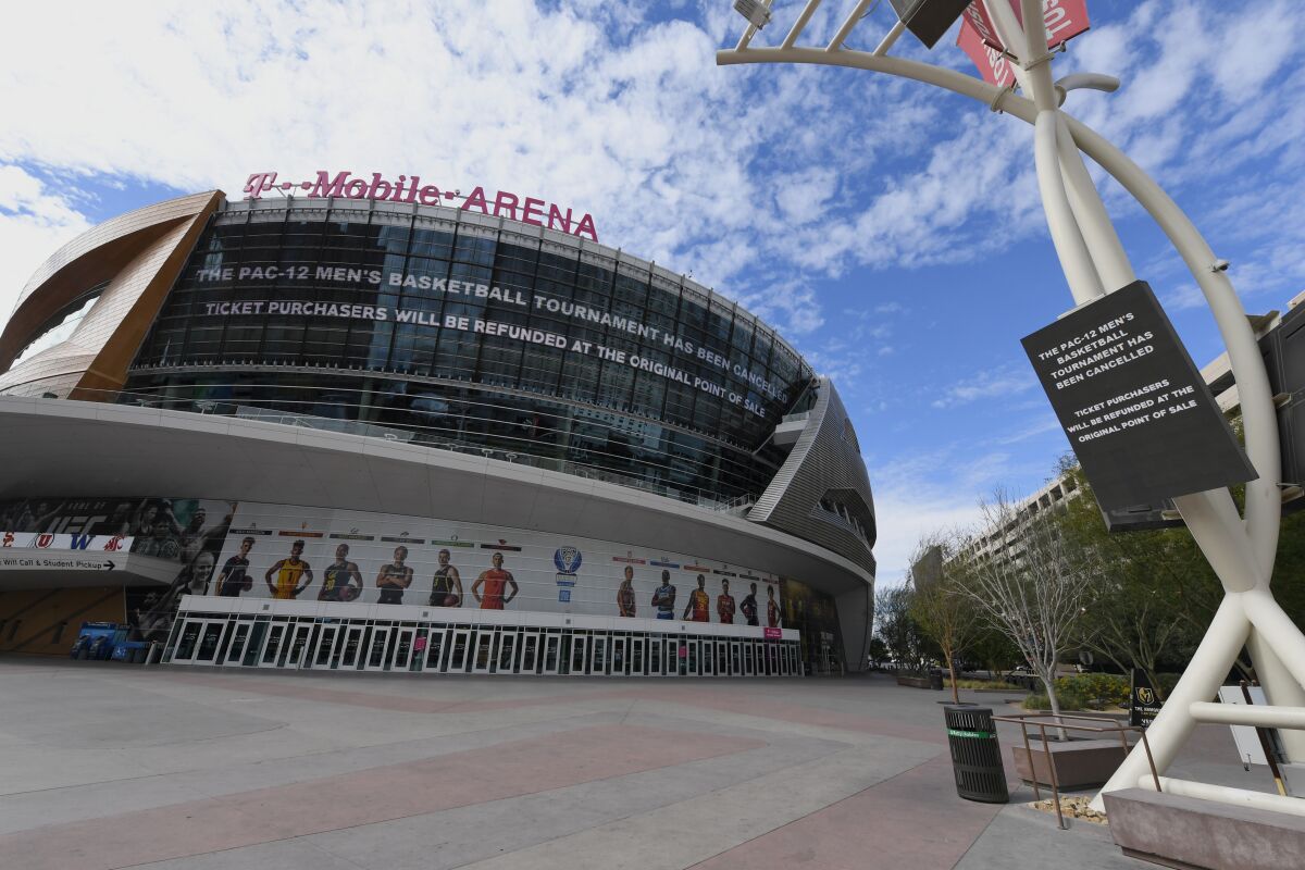 Messages on an LED video wall and a digital sign inform fans of the cancellation of the Pac-12 men's basketball tournament at T-Mobile Arena. 