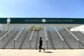 LOS ANGELES, CALIFORNIA MARCH 30, 2020-A jogeer runs past the L.A. Convention Center where it will become a field hospital to help relieve the pressures brought on by the novel coronavirus pandemic. (Wally Skalij/Los Angeles Times)