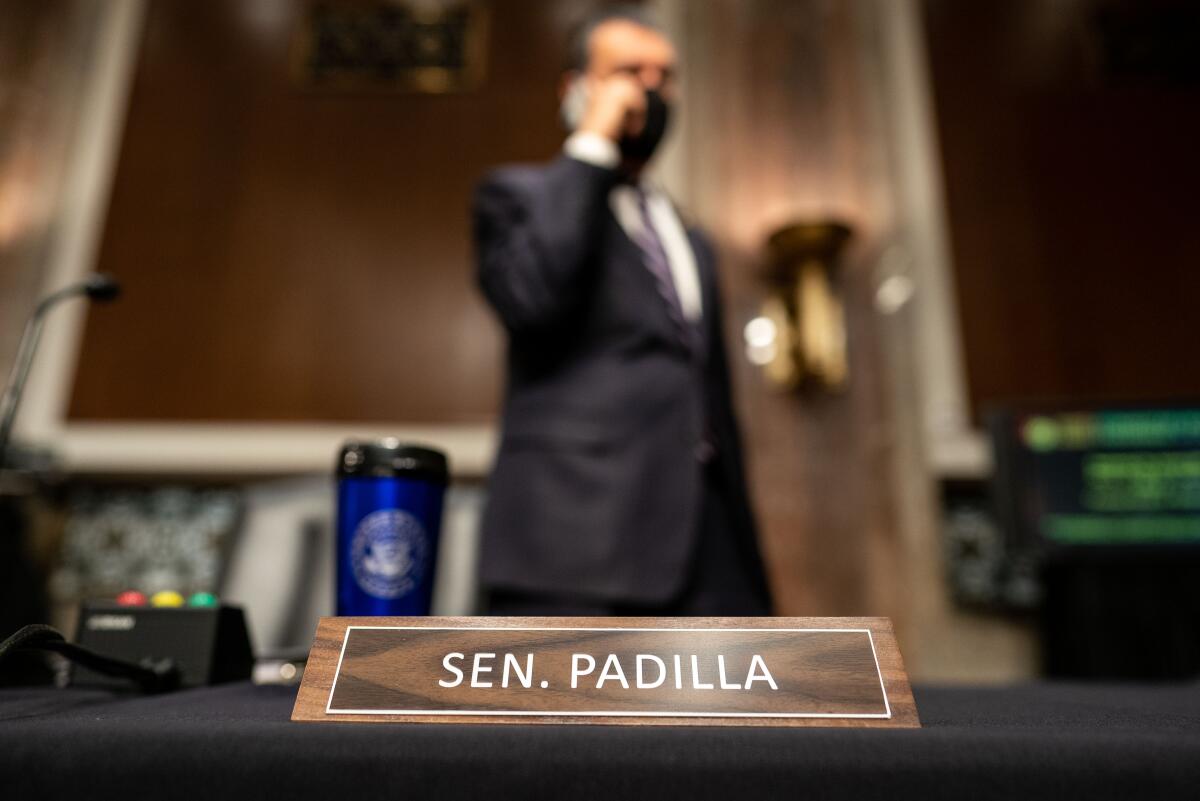 Sen. Alex Padilla stands behind his name plate
