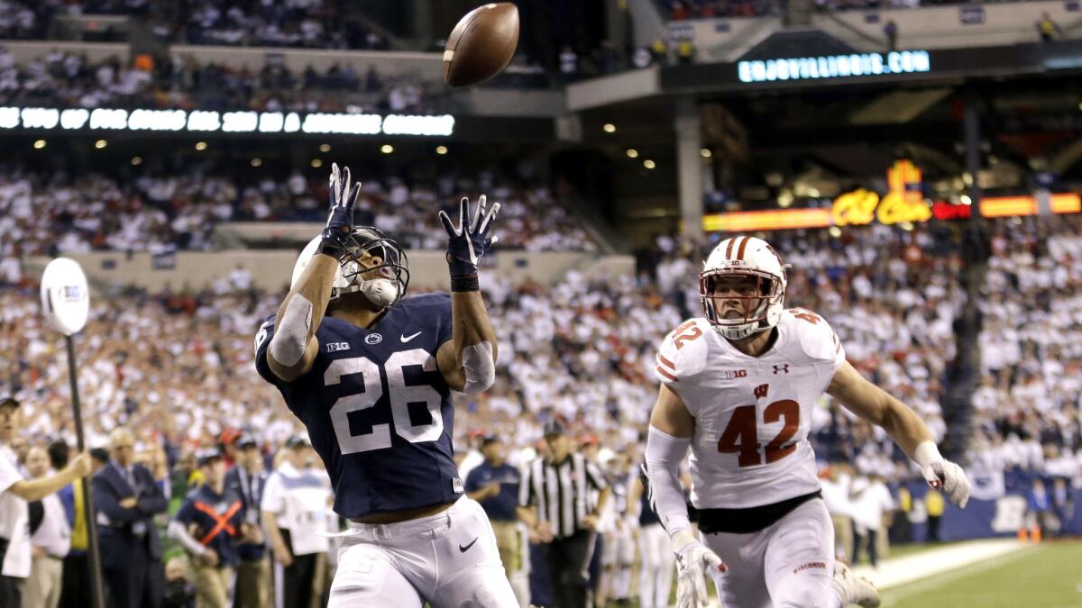 Penn State running back Saquon Barkley (26) makes a 18-yard touchdown catch against Wisconsin's T.J. Watt (42) during the second half of the Big Ten championship game.