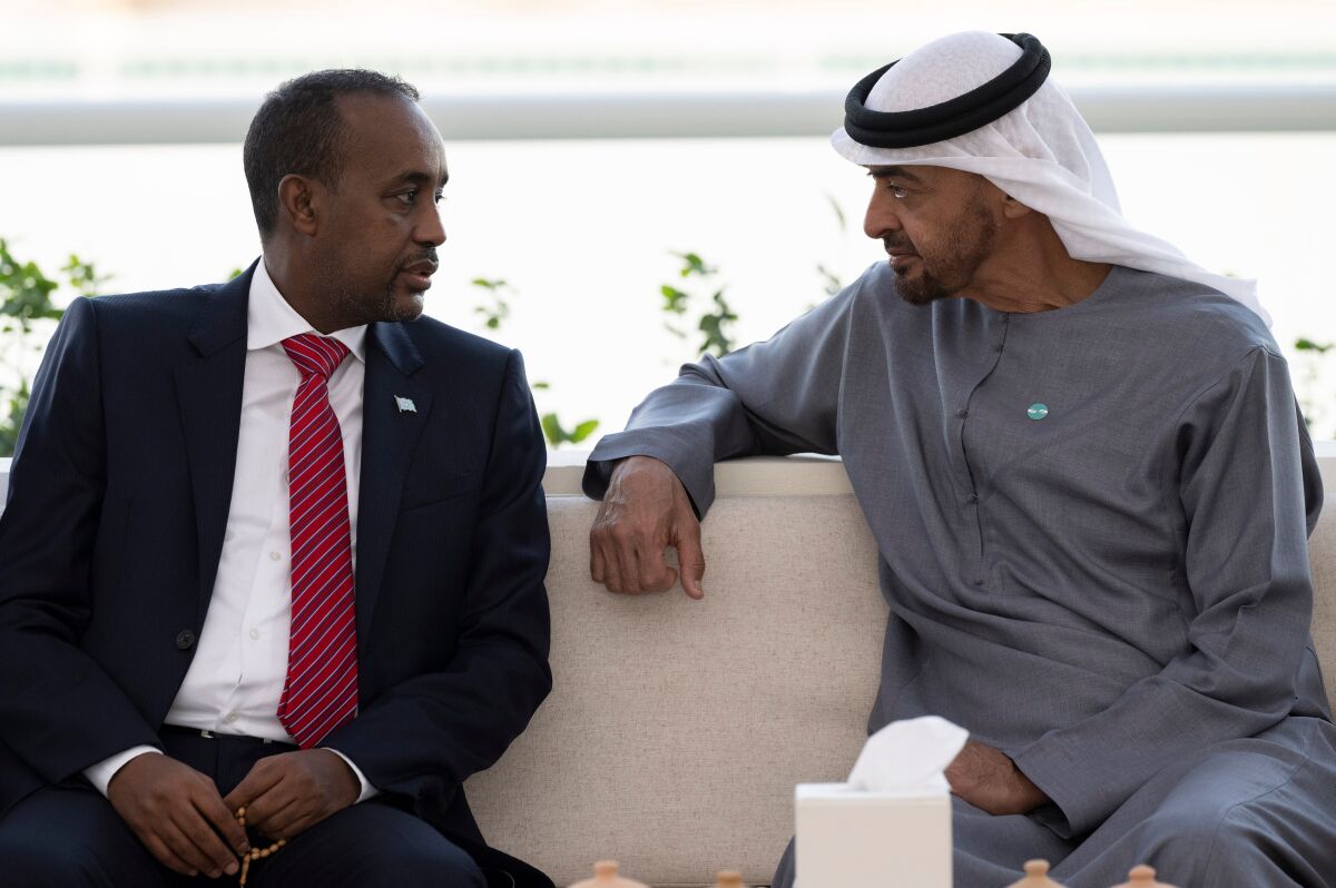 In this photo released by the state-run WAM news agency, Abu Dhabi's powerful crown prince, Sheikh Mohammed bin Zayed Al Nahyan, right, meets with Somali Prime Minister Mohammed Hussein Roble in Abu Dhabi, United Arab Emirates, Tuesday, Feb. 1, 2022. The United Arab Emirates late Tuesday welcomed the prime minister of Somalia's public apology for a Somali operation in 2018 that resulted in the seizure of Emirati aircraft and $9.6 million in cash, wrecking relations between the nations. (Hamad Al Kaabi/Ministry of Presidential Affairs/WAM via AP)