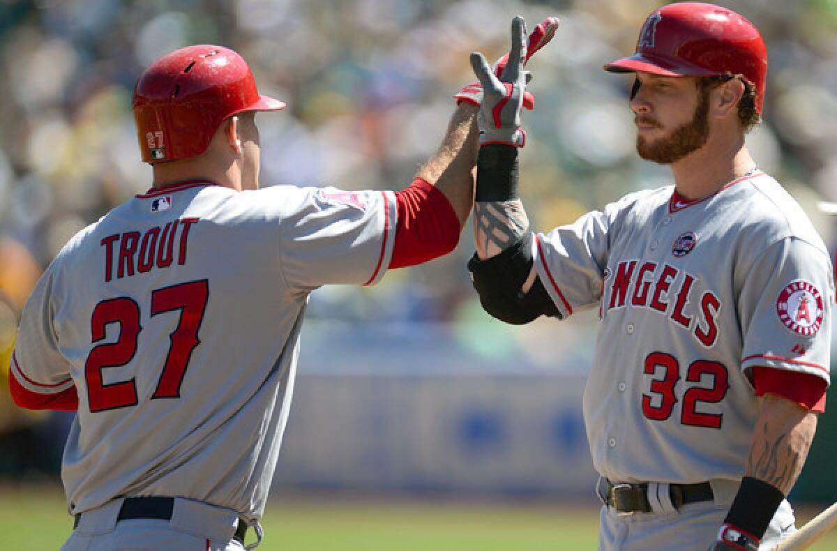 Angels center fielder Mike Trout is congratulated by designated hitter Josh Hamilton after hitting a two-run home run in the first inning against the A's on Wednesday afternoon in Oakland.