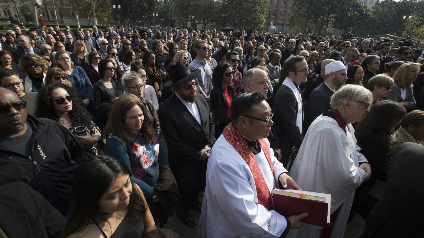 Hundreds of mourners listen to a speaker during a remembrance ceremony honoring slain USC professor Bosco Tjan.