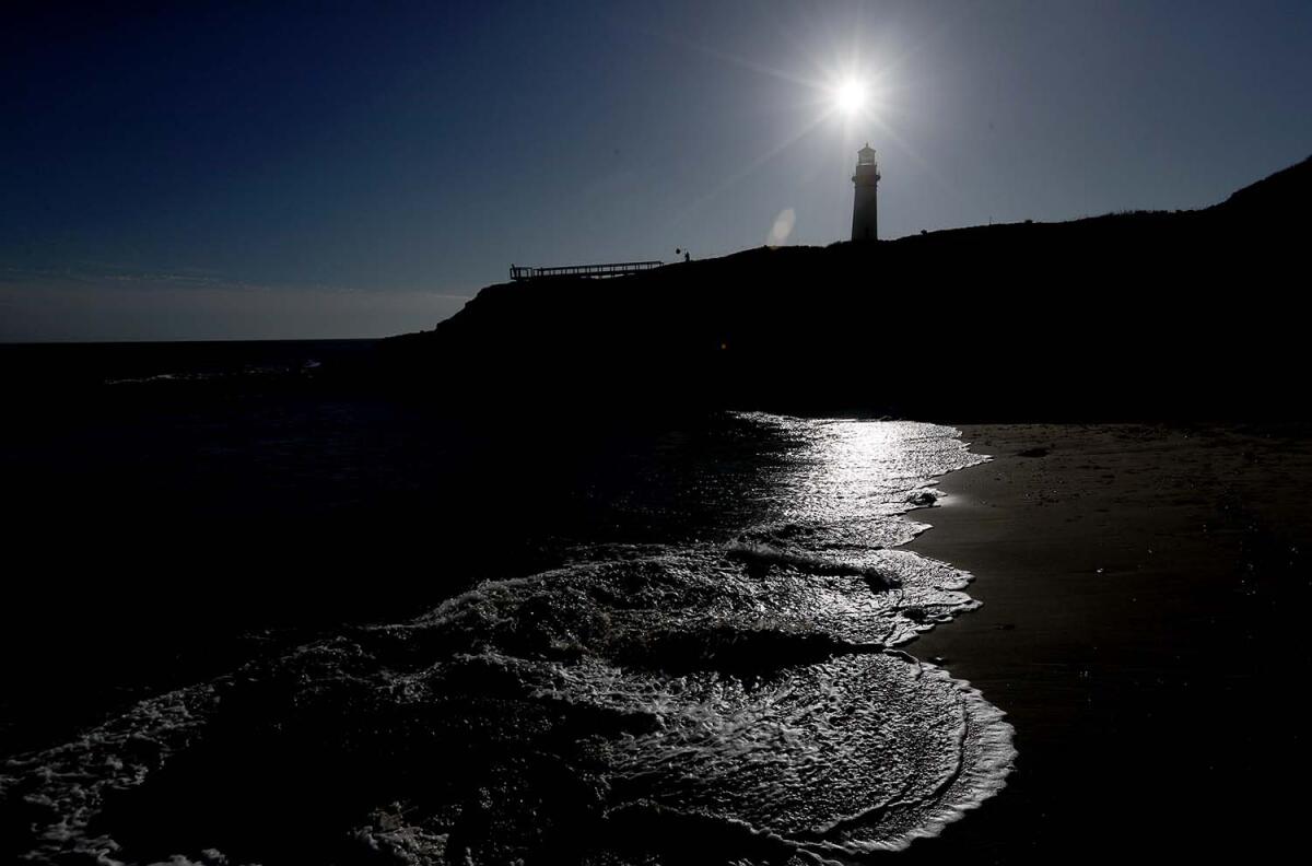 The sun sets behind the Pigeon Point Lighthouse on the coast of San Mateo County.