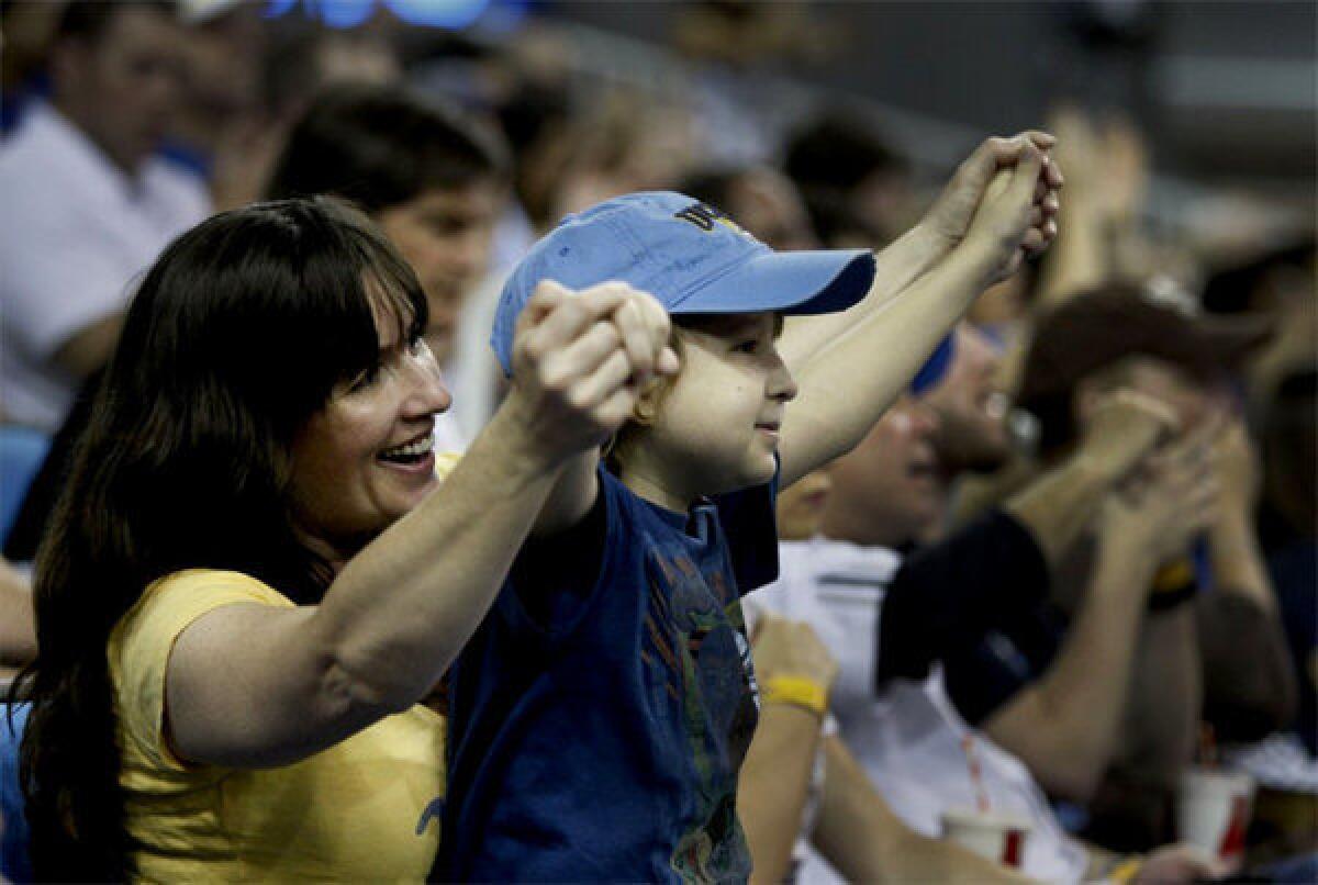 Annie Hughes cheers with her son, Jeffrey Hughes Jr., 9, who is battling cancer, after a Bruins basket during the UCLA-Arizona game.