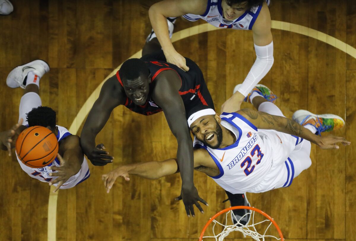 SDSU's Aguek Arop fights for a rebound between Boise State's Emmanuel Akot (left) and Naje Smith.