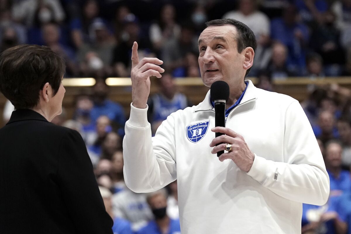Duke coach Mike Krzyzewski points to the banners hanging while speaking to the crowd following the team's NCAA college basketball game against North Carolina in Durham, N.C., Saturday, March 5, 2022. The game was Krzyzewski's final at Cameron Indoor Stadium. (AP Photo/Gerry Broome)