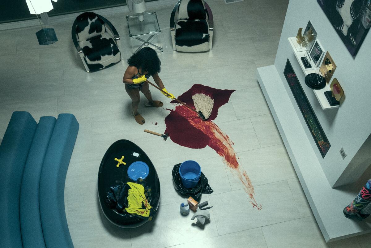 An overhead image of a woman mopping up a bloodstain