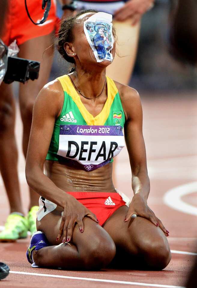 Ethiopia's Meseret Defar puts a picture of the Virgin Mary on her face after winning the gold medal in the 5,000 meters race.