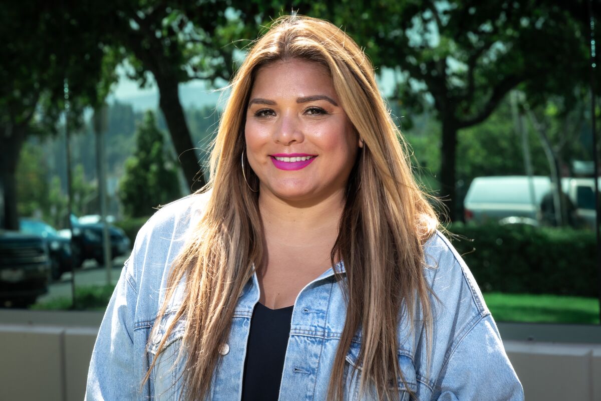 Geena Aguilar pictured from the chest up, in a denim jacket and smiling at the camera