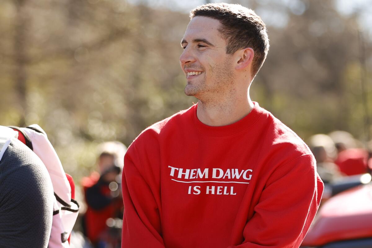 Georgia quarterback Stetson Bennett smiles at the crowd during a parade.