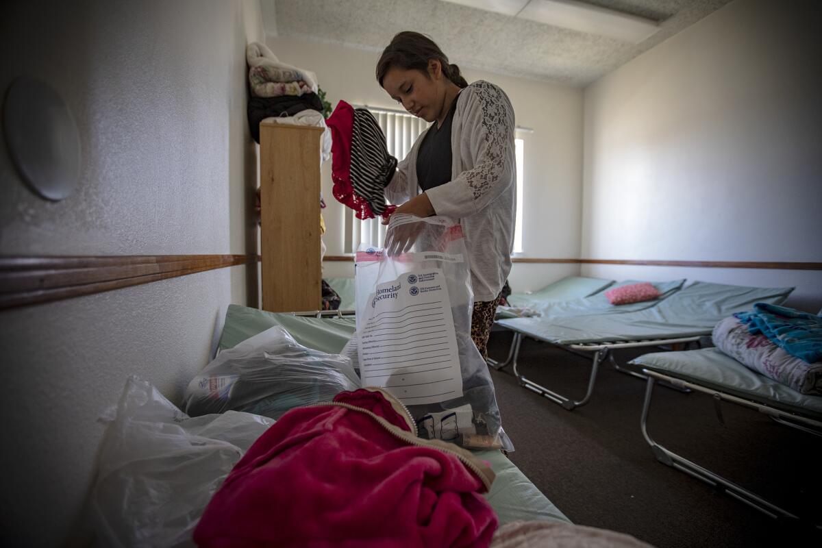 Yenifer Macario Lopez, 17, checks her belongings in a bedroom where she and her father spent night after being dropped at Blythe Central Seventh-Day Adventist Church by U.S. Border Patrol agents in Blythe.