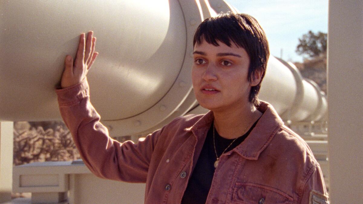 person with short hair puts hand on white pipeline