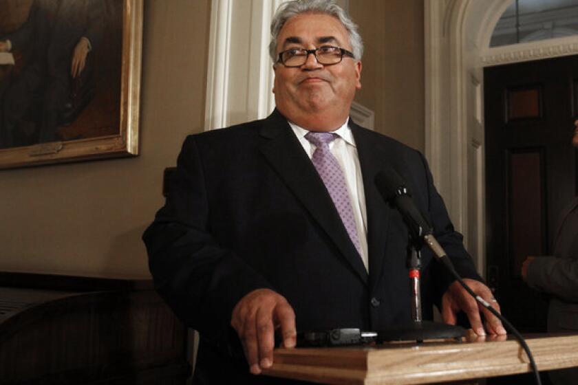 State Sen. Ron Calderon (D-Montebello), right, listens to a question from a reporter at the end of his brief news conference at the Capitol in June.