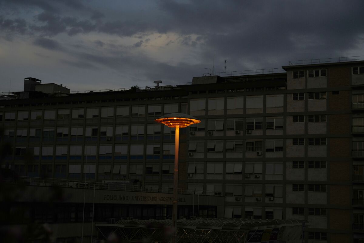 A lit lamp pole is seen in front of the Agostino Gemelli hospital, where Pope Francis was hospitalized Sunday, in Rome, Thursday, July 8 2021. The Vatican says Pope Francis temporarily ran a temperature three days after intestinal surgery, but routine tests proved negative. The Vatican's daily update on Thursday said Francis was continuing to eat and move around unassisted, and had even sent his greetings to young cancer patients at Rome's Gemelli hospital. (AP Photo/Gregorio Borgia)