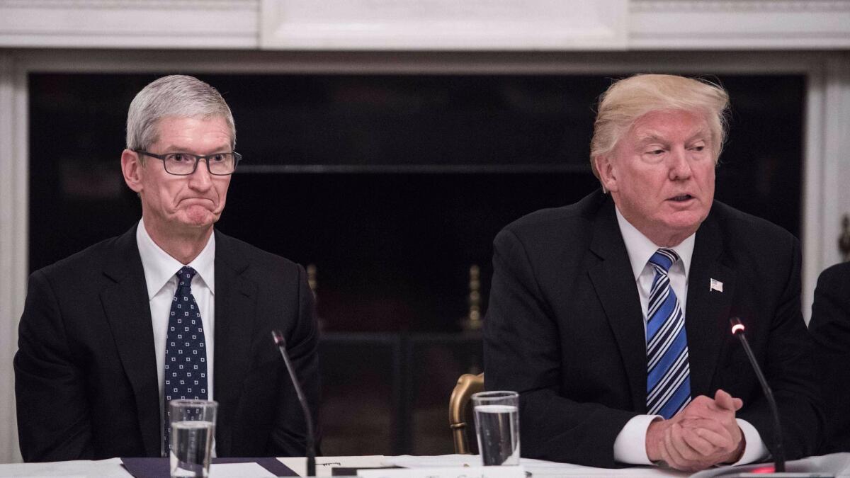 Apple CEO Tim Cook listens to President Trump during an American Technology Council roundtable at the White House in Washington in June.