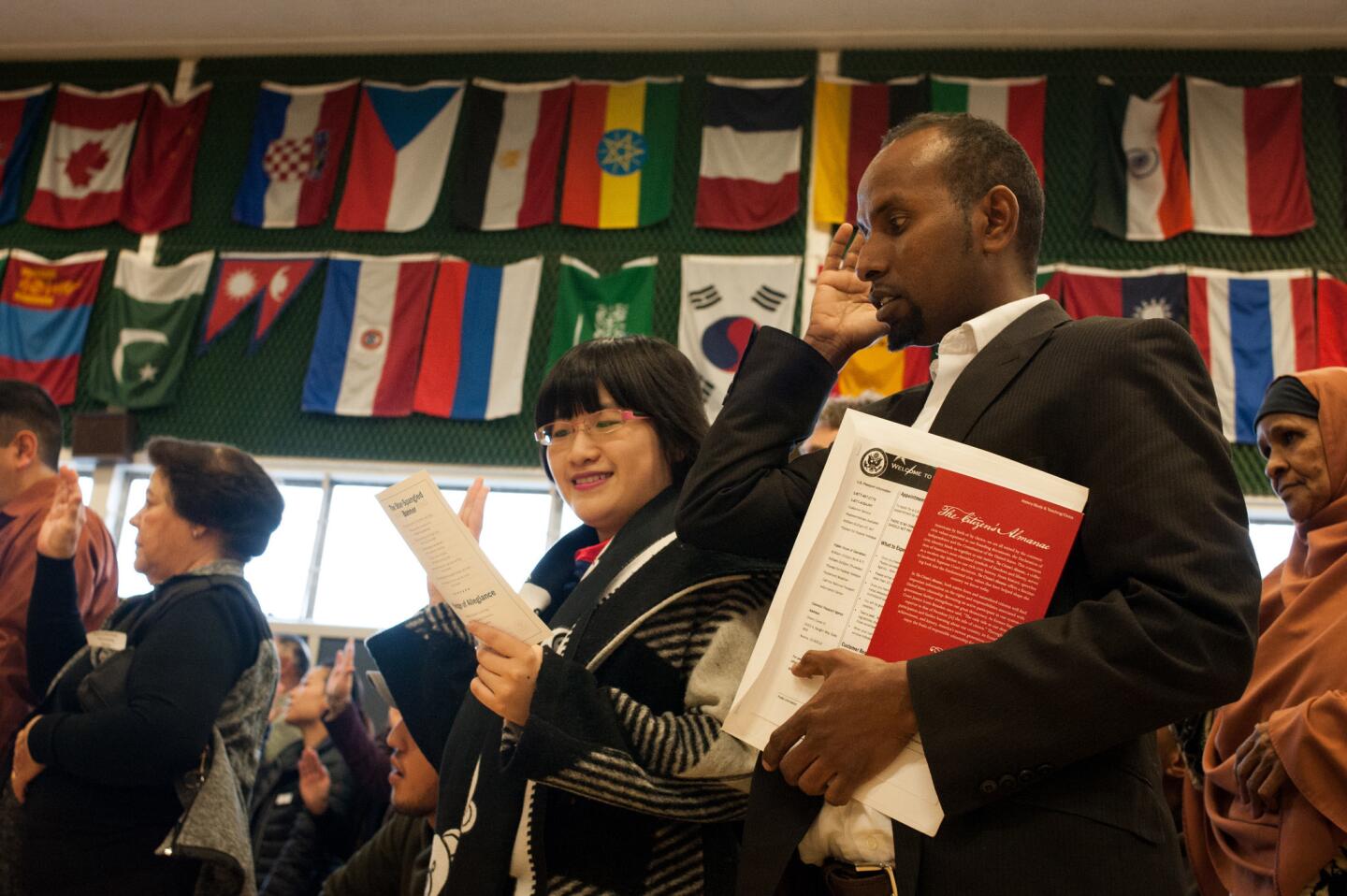 Omar Ibrahim, center right, and Yuanhao Zhuge, center left, take the oath of allegiance during a naturalization ceremony at Dunn Elementary in Fort Collins, Colo., on Feb. 3, 2017. Twenty-six people from 13 countries became U.S. citizens at the ceremony.