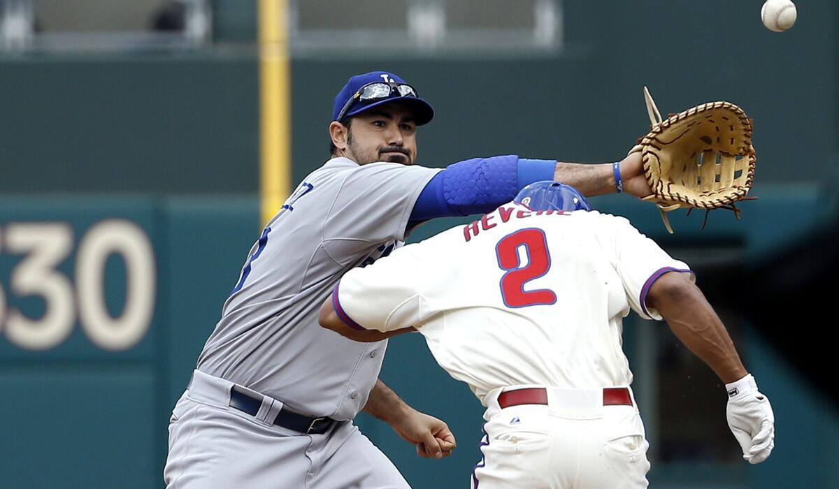 Phillies center fielder Ben Revere (2) ducks to avoid the outstretched arm of Dodgers first baseman Adrian Gonzalez, who can't catch an errant throw from pitcher Dan Haren in the sixth inning Saturday. Revere advanced to third on the error.