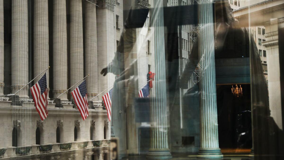 Flags along the New York Stock Exchange are reflected in the window of Federal Hall.