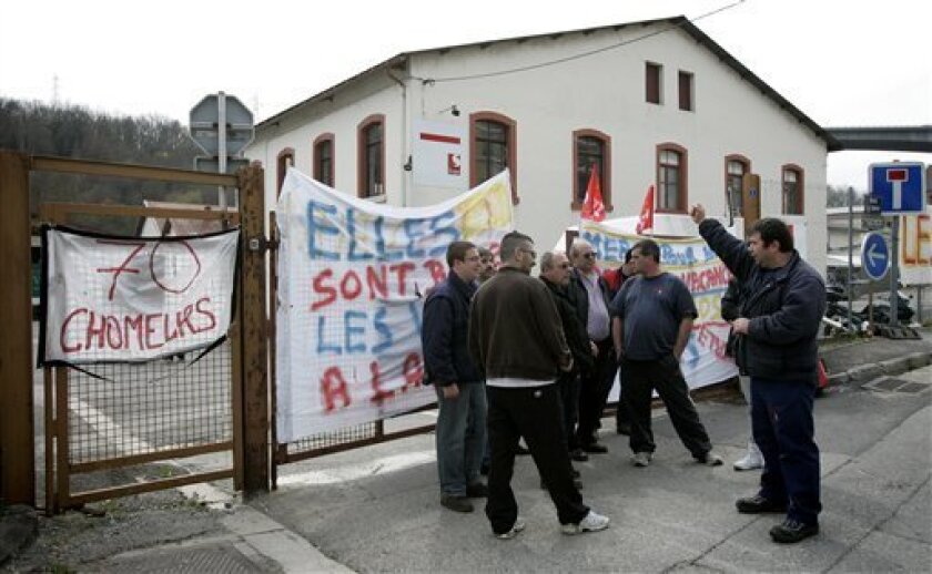 Workers for Scapa, which manufactures adhesive tape for the auto industry, protest against the the factory's closure, in Bellegarde, France, Wednesday, April 8, 2009. Employees of Britain's Scapa Group PLC barred the senior managers from leaving Tuesday after negotiations over terms of the factory closure broke down. Workers blocked the entrance to the site with a truck, said Scapa's European finance director, Ian Bushell, who described it as a "non-aggressive action." Sign at left reads, "70 unemployed workers". (AP Photo/Laurent Cipriani)