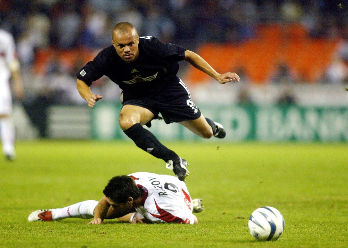 File-This Nov. 1, 2003, file photo shows DC United midfielder Earnie Stewart jumping over a slide tackle by Chicago Fire forward Ante Razov in the first half of an MLS soocer match in Washington. The three-time World Cup veteran Stewart has been hired as general manager of the U.S. men's national soccer team, a new position created after the Americans failed to qualify for this year's tournament. The U.S. Soccer Federation said Wednesday the 49-year-old will start work Aug. 1.