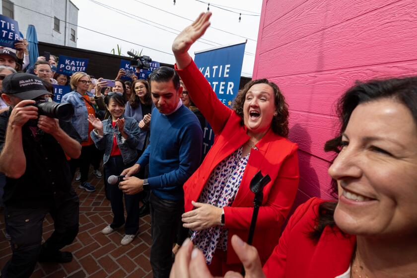 Long Beach, CA - February 17: Rep. Katie Porter, center, waves to supporters with Rep. Robert Garcia, left, and Assemblywoman Cottie Petrie-Norris, right, at a Porter campaign event at Lola's Mexican Cuisine on Saturday, Feb. 17, 2024 in Long Beach, CA. (Brian van der Brug / Los Angeles Times)