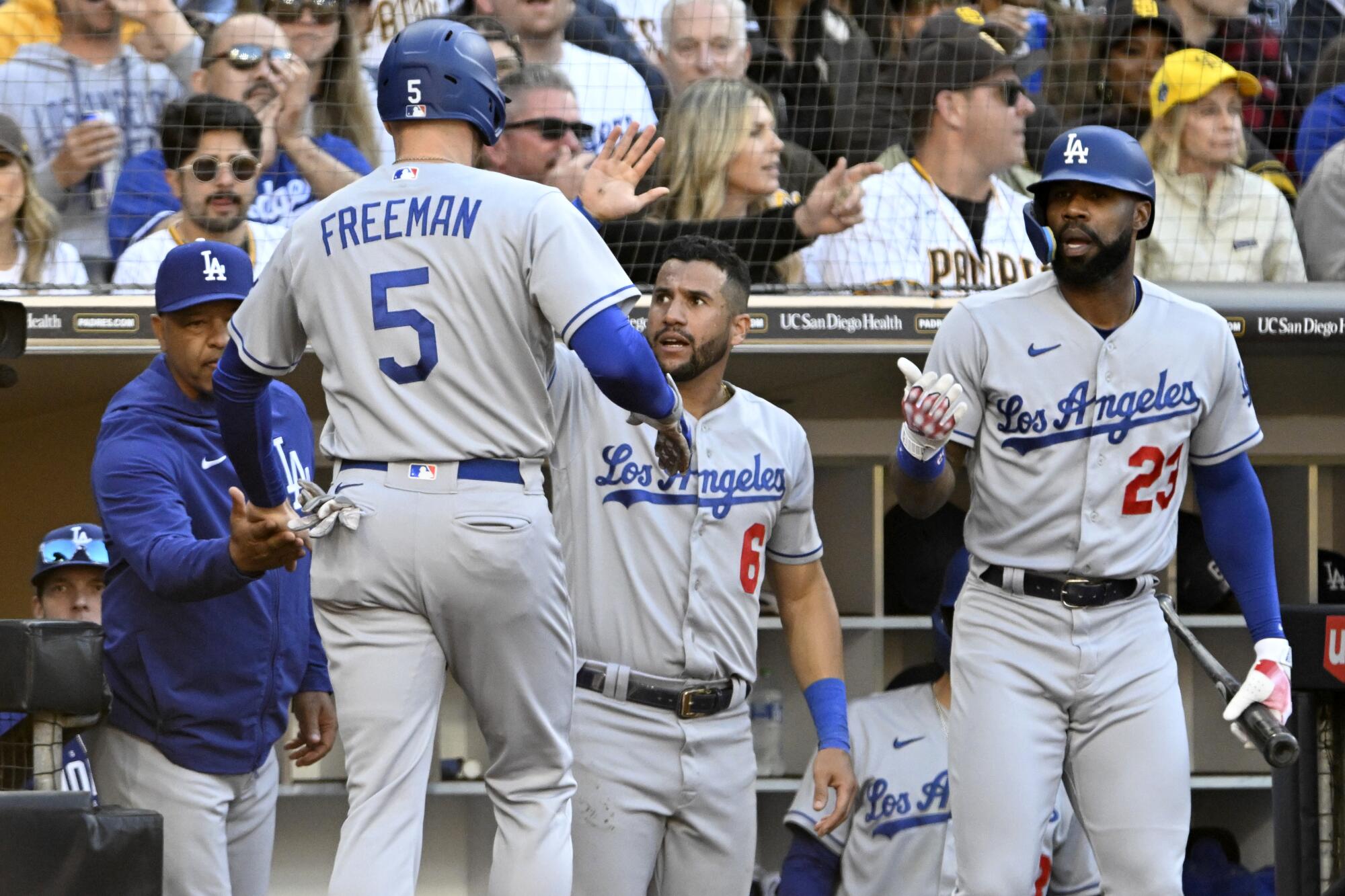 Freddie Freeman celebrates with (from left) Dodgers manager Dave Roberts, David Peralta and Jason Heyward after scoring.