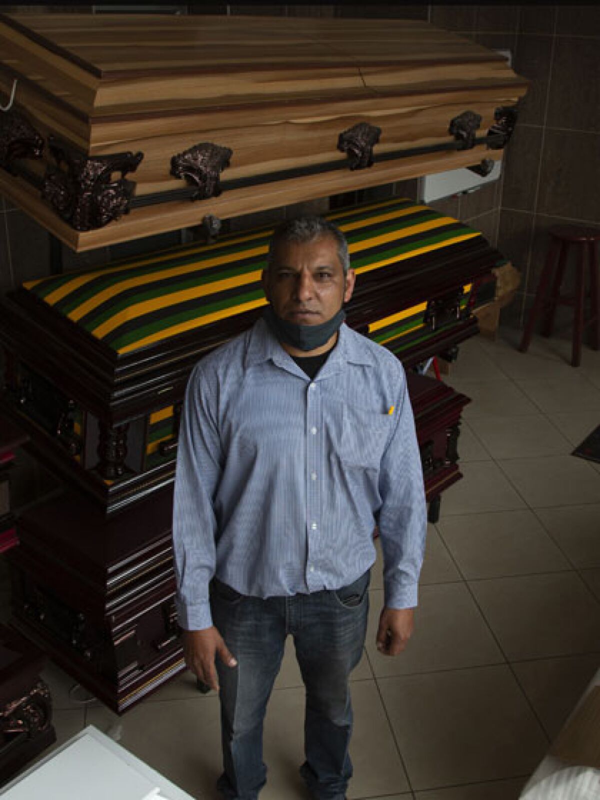 Casey Pillay in front of stacked coffins at his Johannesburg, South Africa,  business.