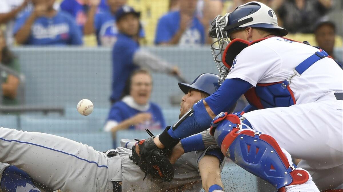 New York Mets second baseman Jeff McNeil is safe at home as Yasmani Grandal of the Dodgers loses control of the ball.