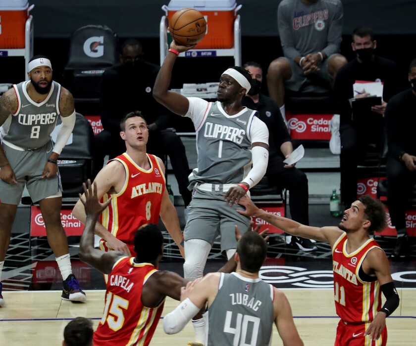 Clippers guard Reggie Jackson puts up a shot between a trio of Atlanta Hawks defenders.