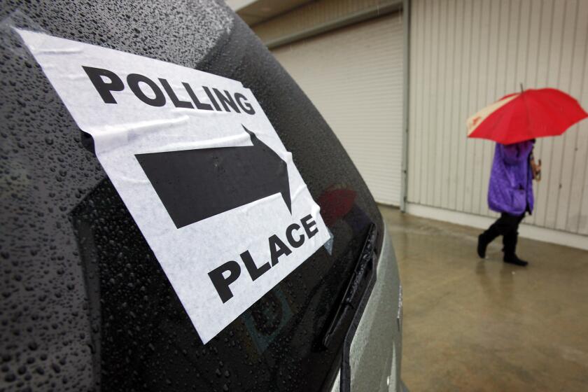 Seib, Al –– – VENICE, CA – MAY 17, 2011: A voter uses her umbrella in the rain after voting at the LA County Lifeguard Headquarters polling location on Ocean Front Walk in Venice on a cold and wet Tuesday morning as few voters turned out to vote in the race to elect a successor for Representative Jane Harman and a LAUSD board member. (Al Seib / Los Angeles Times)