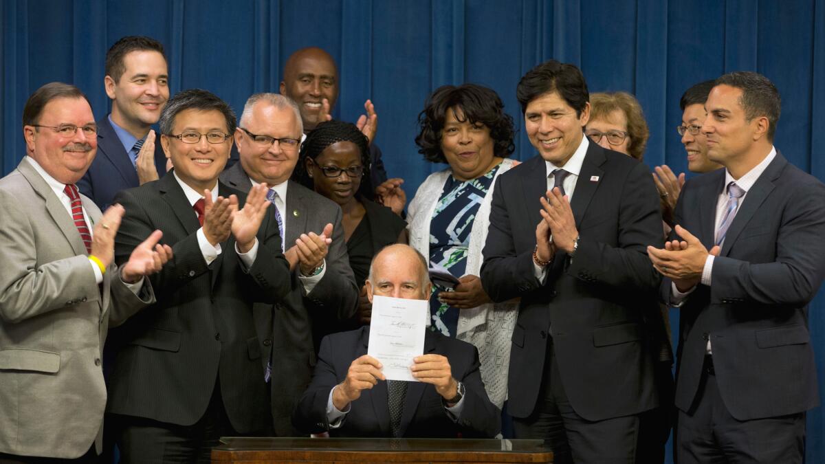 Gov. Jerry Brown displays a piece of legislation he signed.