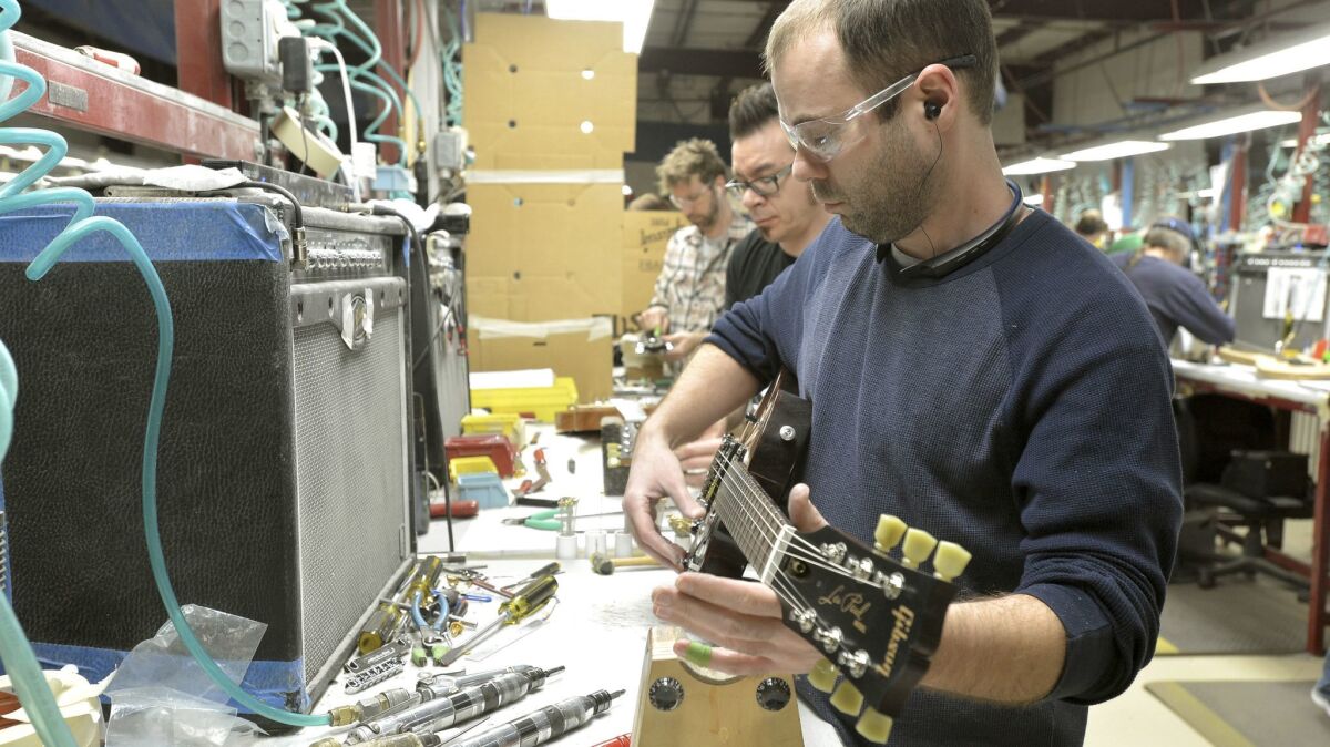 Loren Amsbary makes final adjustments on new guitar at the Gibson guitar manufacturing plant. (Christopher Berkey / For The Times)