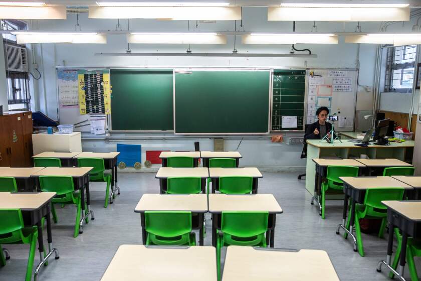 In this photo taken on March 6, 2020, primary school teacher Billy Yeung records a video lesson for his students who have had their classes suspended due to the COVID-19 coronavirus, in his empty classroom in Hong Kong. - In Hong Kong, schools have been shut since early February, with the closure now set to last until after Easter. Many teachers are turning to conference call applications to interact with students, but that requires good WiFi access and computer literacy. (Photo by ISAAC LAWRENCE / AFP) / TO GO WITH AFP STORY CHILDREN-EDUCATION-HEALTH-VIRUS-CHINA-JAPAN-SKOREA-HONG KONG-SINGAPORE,FOCUS (Photo by ISAAC LAWRENCE/AFP via Getty Images)