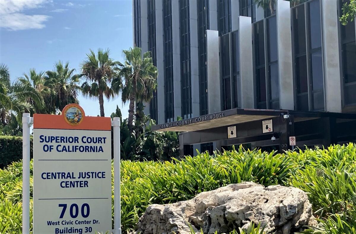 A sign, with a courthouse in the background. 