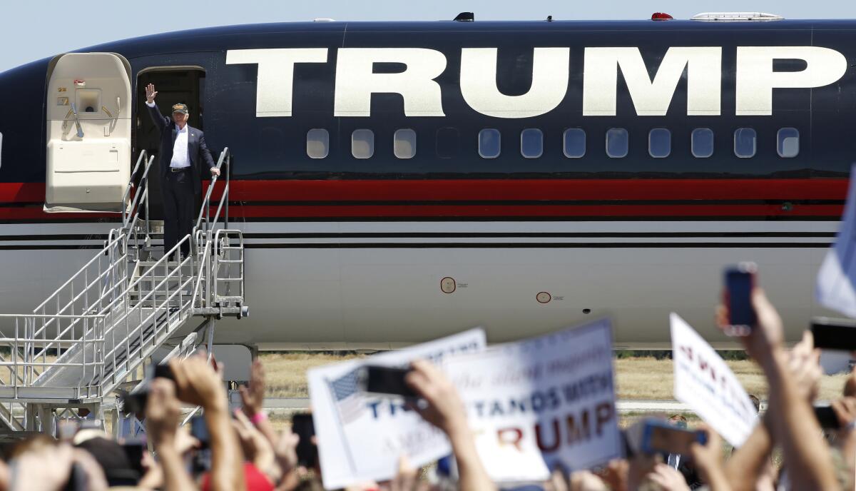 Republican presidential candidate Donald Trump waves to the crowd as he disembarks from his plane for a campaign rally at the Redding Municipal Airport, Friday, June 3, 2016, in Redding, Calif.
